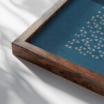 Blad met licht en donkerblauwe helften met uitgespaard hexagonaal motief 1974 1984 Unknown close up dark wood mockup