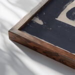 Fantasie profielkop naar rechts in een witte rechthoek omgeven door zwart rechtsonder is het zwart gewassen 1920 Samuel Jessurun de Mesquita close up dark wood mockup