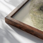 Ontwerp voor de aardewerkdecoratie op een schaal met een landschap 1920 Theo Colenbrander close up dark wood mockup