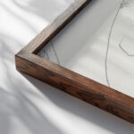 Ovaal met een kop in profiel naar rechts twee benen en een kop met gesloten ogen 1943 11 24 Samuel Jessurun de Mesquita close up dark wood mockup